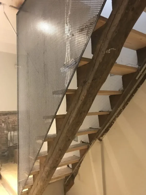 Escalera de madera con rejillas de hierro forjado