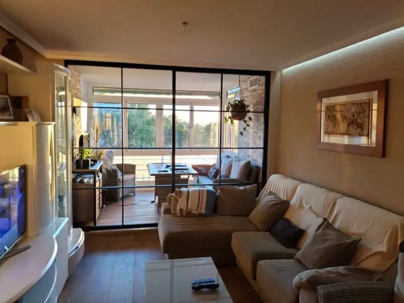 Mampara divisoria con diseño de cuadrícula que divise el salón y la terraza en una propiedad