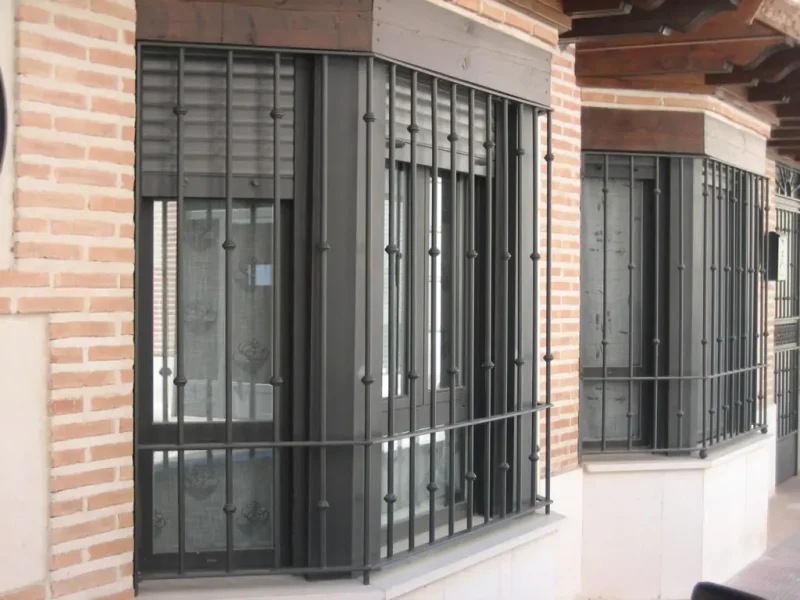 Rejas de hierro forjado instaladas en varias ventanas de una propiedad que dan a la calle